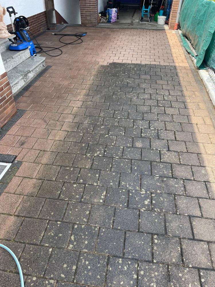 Hof vor der Garage, vorne noch dunkel und fleckig, hinten bereits hell gereinigt
