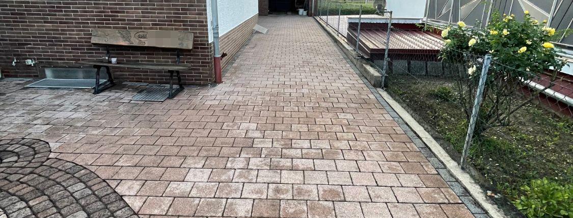 Gereinigter Pflasterweg neben einem Haus