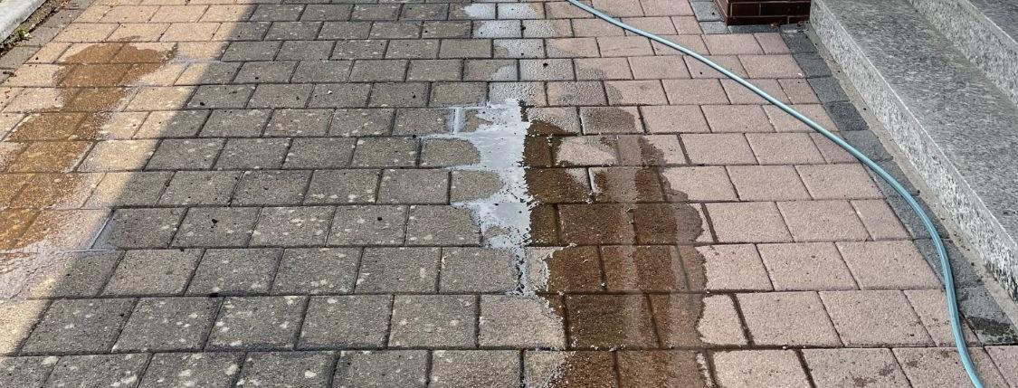 Pflasterweg, links noch grau, rechts frisch gereinigt
