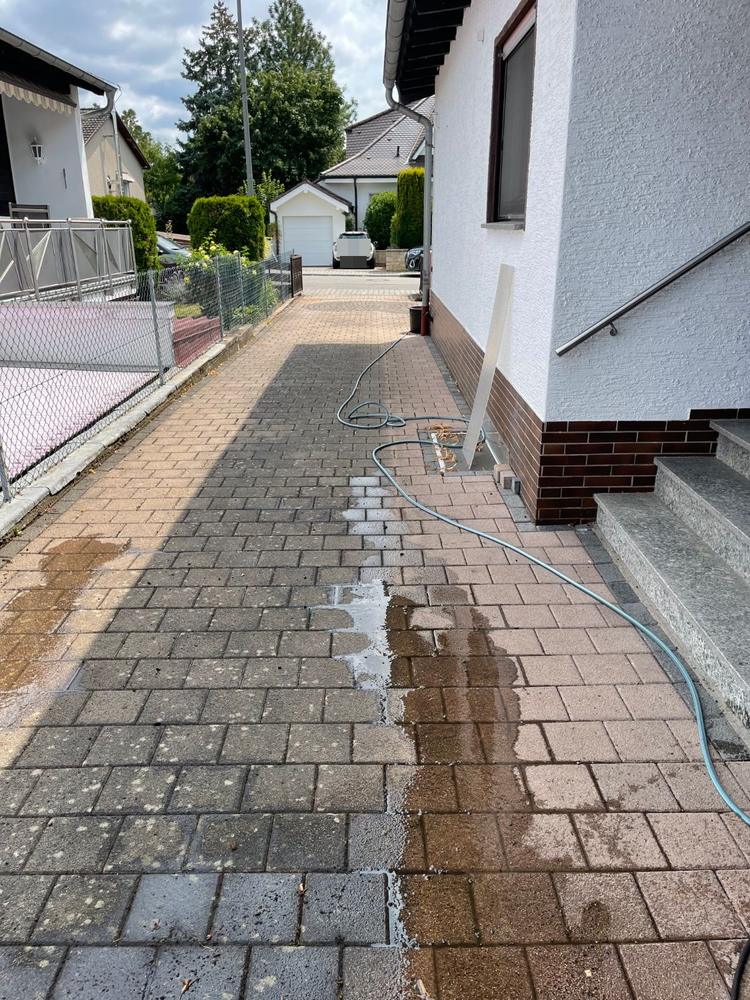 Weg neben dem Haus, links noch grau, rechts frisch gereinigt und rötlich